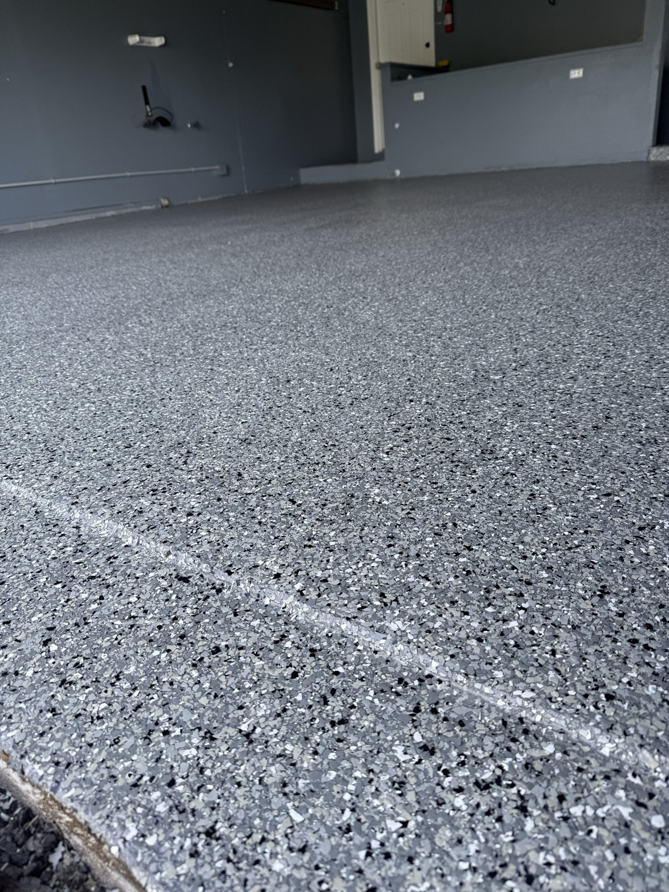 Close-up of gray flake epoxy garage floor coating installed by Elite Epoxy & Coatings