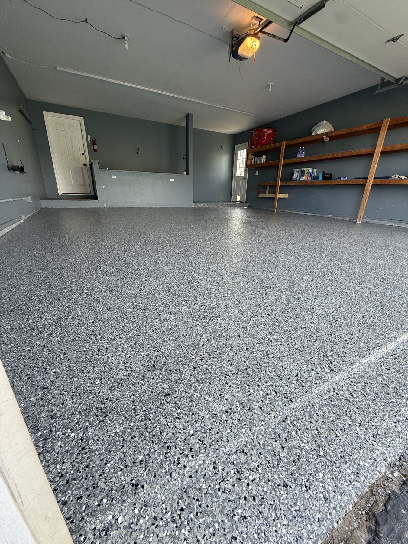 Finished gray flake epoxy garage floor with clean coated edge